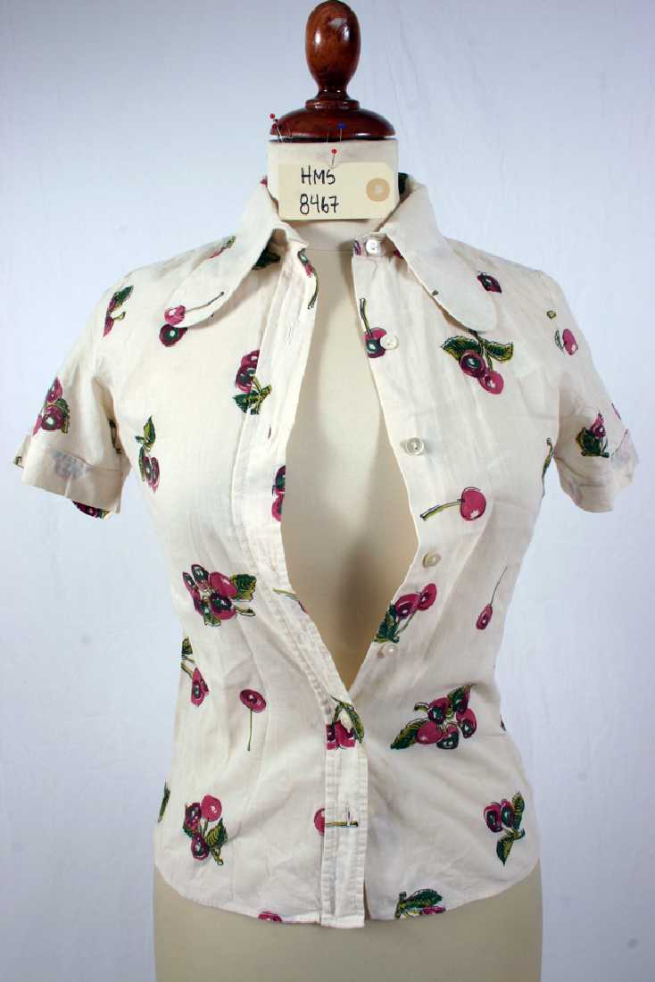 hvit kortermet bomullsskjorte med lange snipper, knapping i front, smal med innsving i midje.Kirsebær-mønstret stoff. 