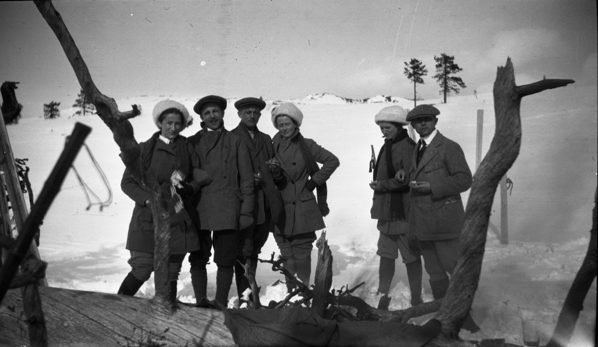 Fotoarkivet etter Gunnar Knudsen. Mennesker på skitur på fjellet.  Her har de tatt seg en matpause.