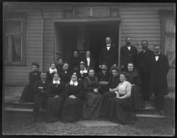 En gruppe fotografert på prestegårdstrappen, både menn og kv