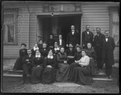 En gruppe fotografert på prestegårdstrappen, både menn og kv