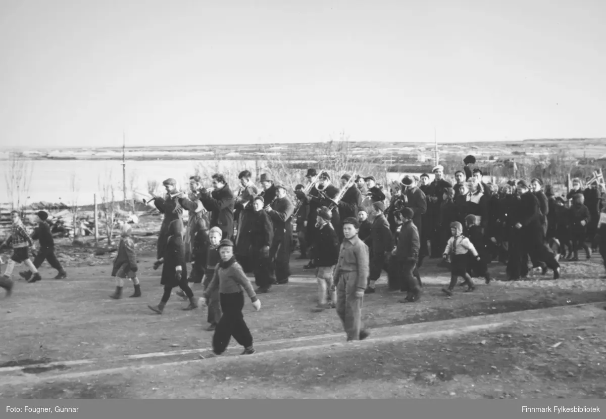 8. mai 1945 i Vadsø. En gruppe barn og voksne går i tog. Et korps er også med.