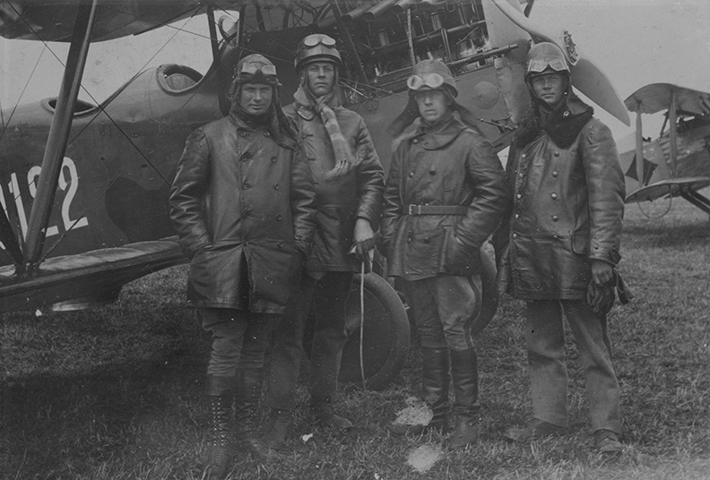 Grupporträtt av fyra militära flygare framför flygplan Dront nummer 0122 vid Hästholmen, 1923.