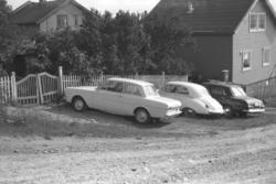 Tre biler står utenfor Hauges hus i Vadsø. Til venstre på bi