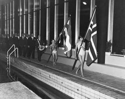 Opptog inne i Harstad svømmehall, med flaggbærere, trommesla