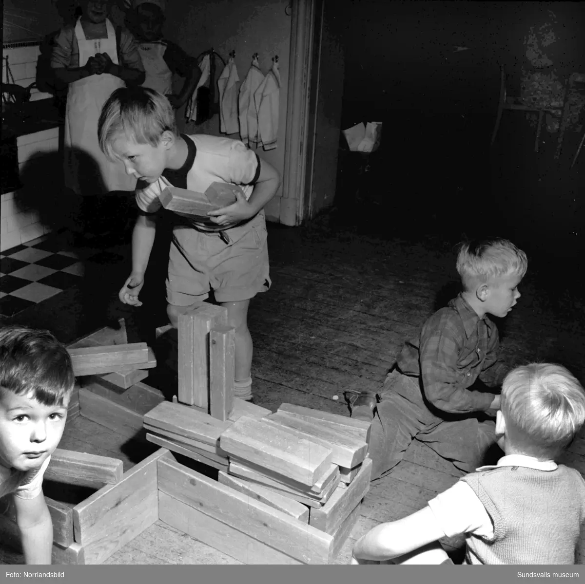 Vita Bandets Kindergarten (lekskola) med glada barn som stökar i köket.