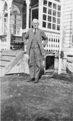 Eldre mann framfor inngangsparti, Einar Olsen ved huset til 