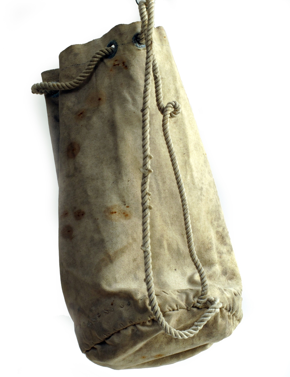 Seilmakerpose med 1 kylle og en pinne. Tromøy. 

Pose av seilduk,  sydd for hånd, nylonsnor i grønnirrete maljer.  Rund bunn,  to sidesømmer.