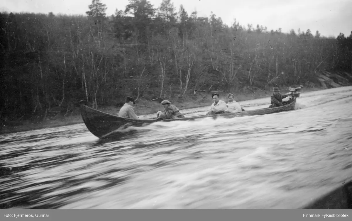 En elvebåt suser av sted på elva Karasjohka. Bildet kan være tatt på en tur fra Bàktemohkenjàrga til Iskuasjohka i mai 1946. Personene ombord er ukjent.