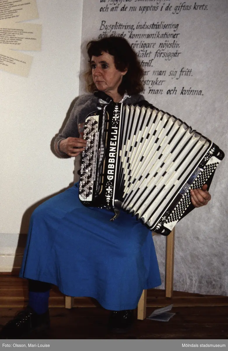 En kvinna spelar dragspel i utställningen "Från näckens polska till rockens roll" på Mölndals museum, Norra Forsåkersgatan 19 i Mölndal. Den pågick från 1 december 1990 till 31 december 1991.