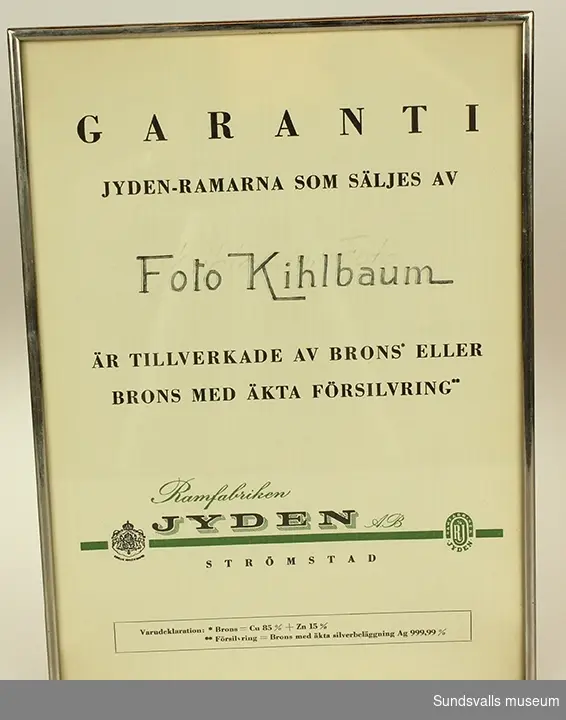 Bär texten Garanti Jydenramarna som säljes av Foto Kihlbaum är tillverkade av brons eller brons med äkta förgyllning. Ramfabriken Jyden AB Strömstad.