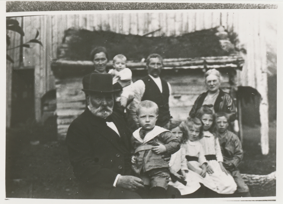 Gruppebilde av en familie sammen med Børre Berli foran et hus.