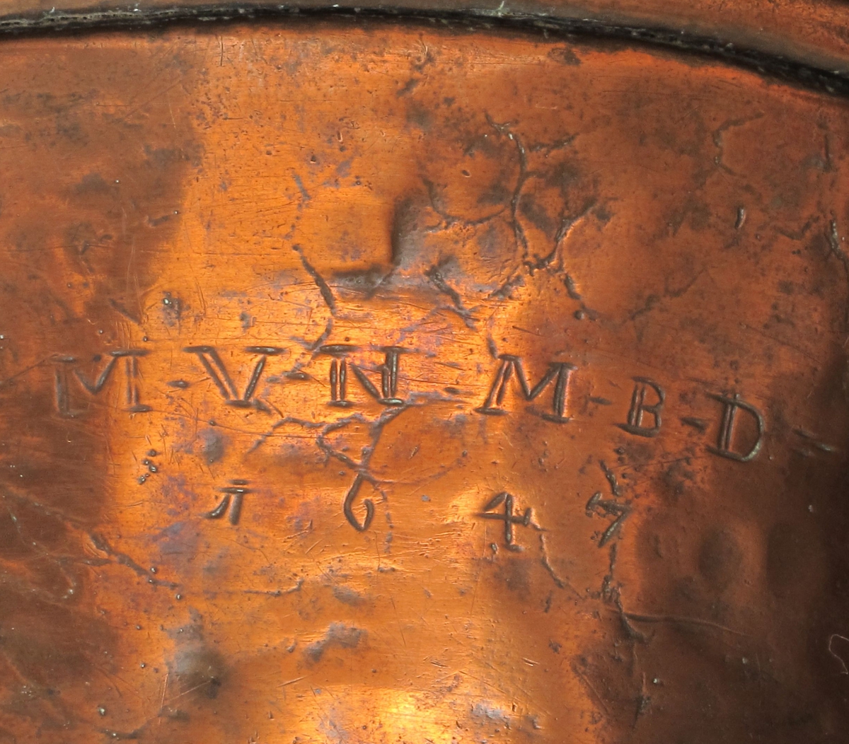 Dørslag, av kobber. Skålform med litt skrå sider, huller i bunnen, rundet brem, to  oppstående  hanker.   Utvendig i siden innrisset: M.V.N.   M.B.D. 1647.