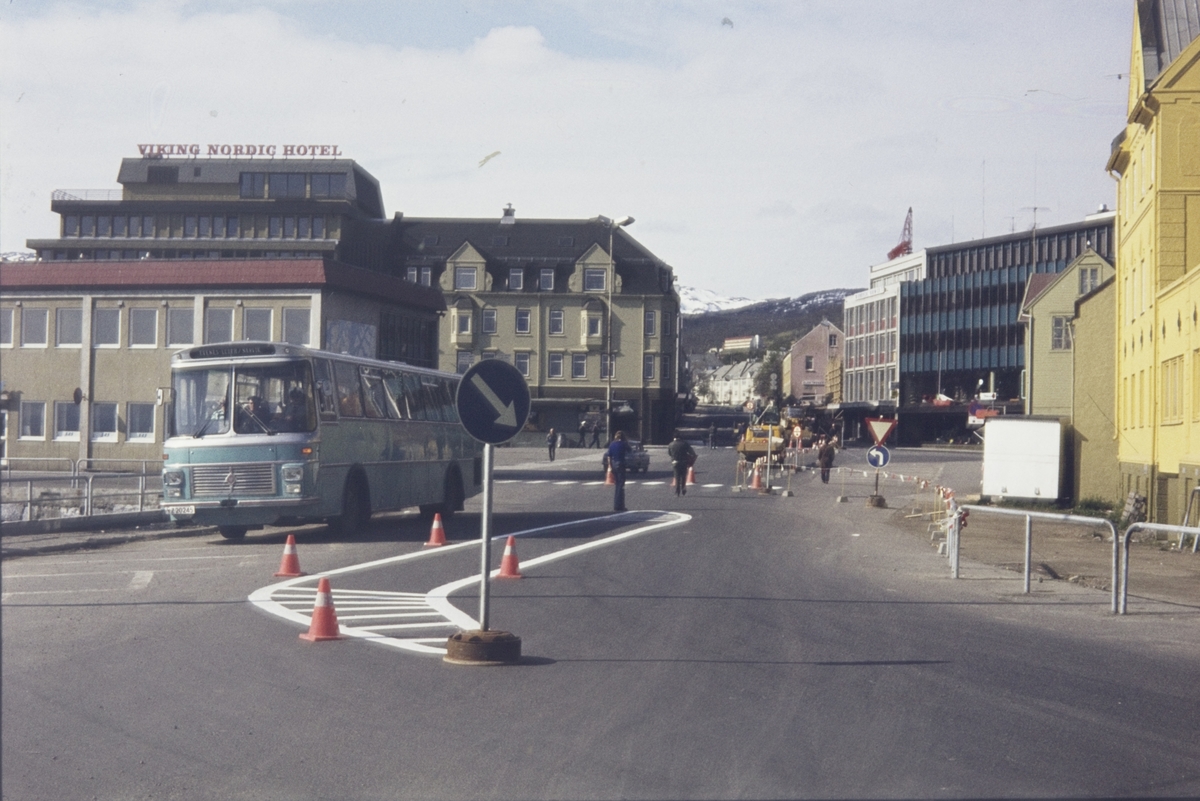 Buss med rutebilstasjonen og Torvet i bakgrunnen.