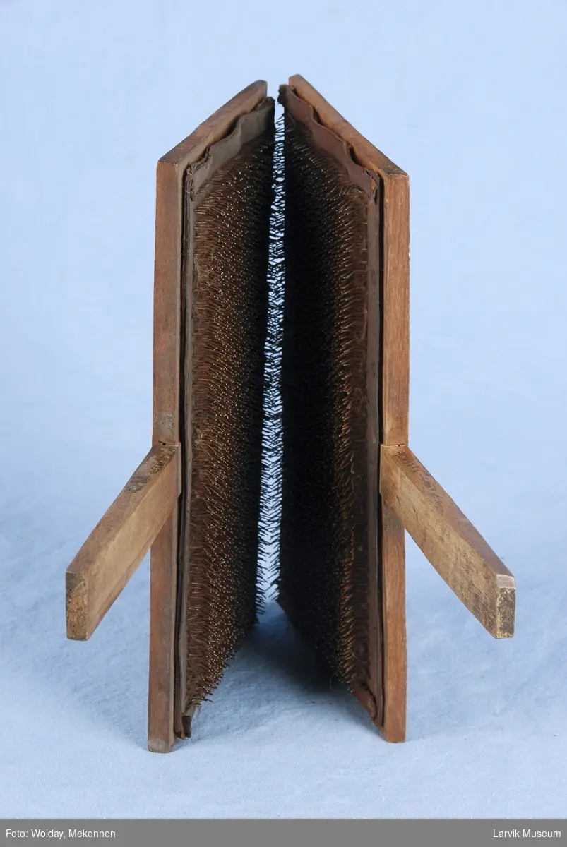 Form: To deler : To rektangulære stykker med håndtak. De er belkledd med skinn inni og i dette skinnet er det festet tett i tett med bøyde metall nåler.
