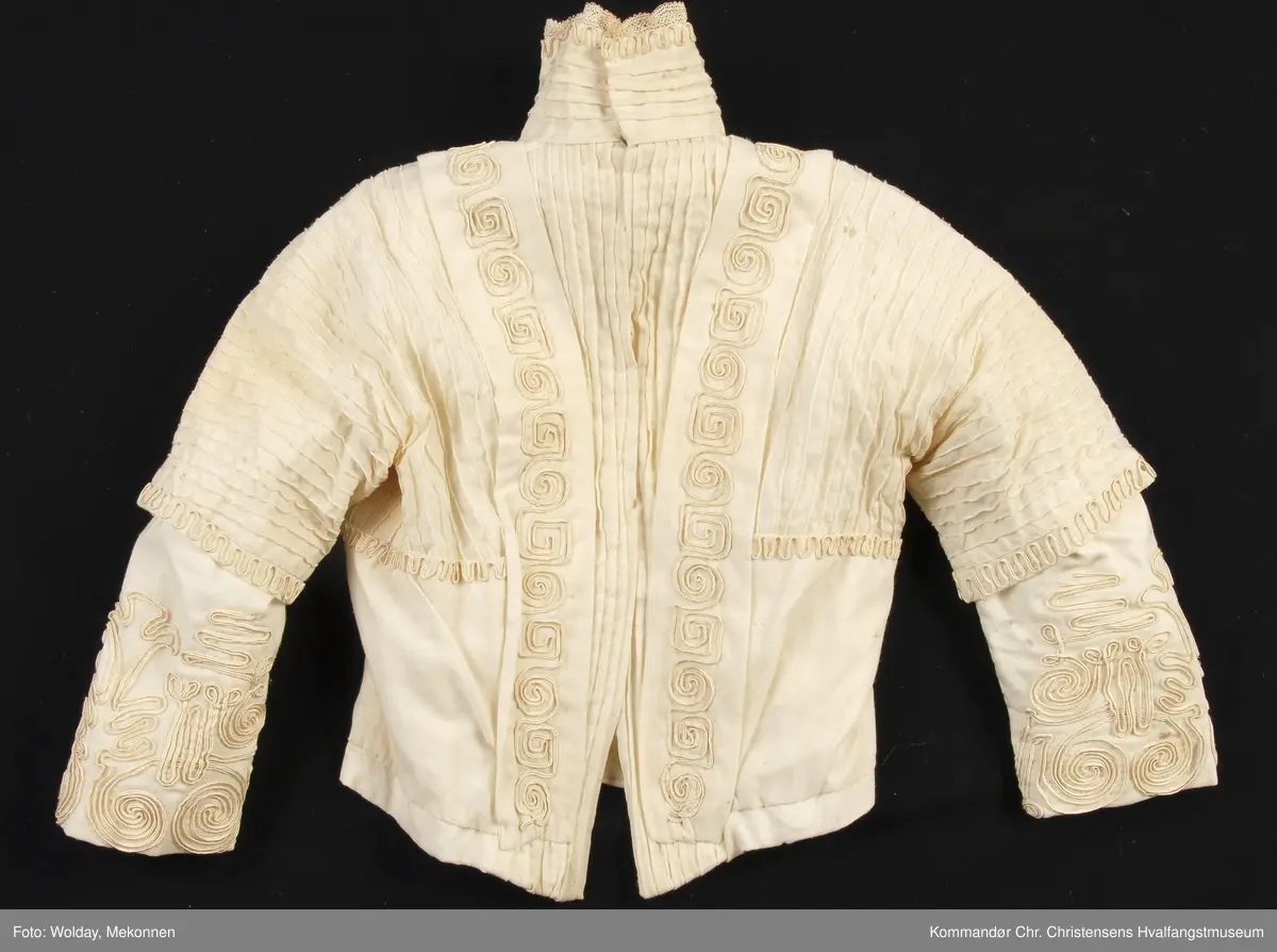 Teknikk: Håndarbeid. Sydd både for hånd og på maskin Høy krave av bomullsblonde. 3/4 lange ermer m/albulange overermer
