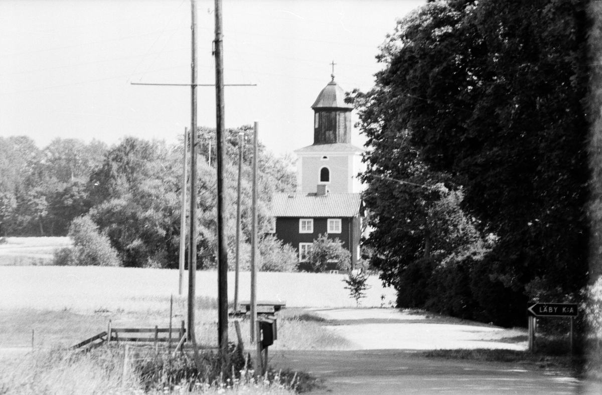 Vy från Västerby över Läby kyrka, Läby socken, Uppland 1975