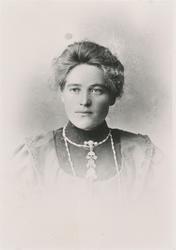 Portrett av en kvinne med finklær og søljer.