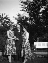 Fotosamling etter Cappelen. To kvinner og en mann i hagen fo