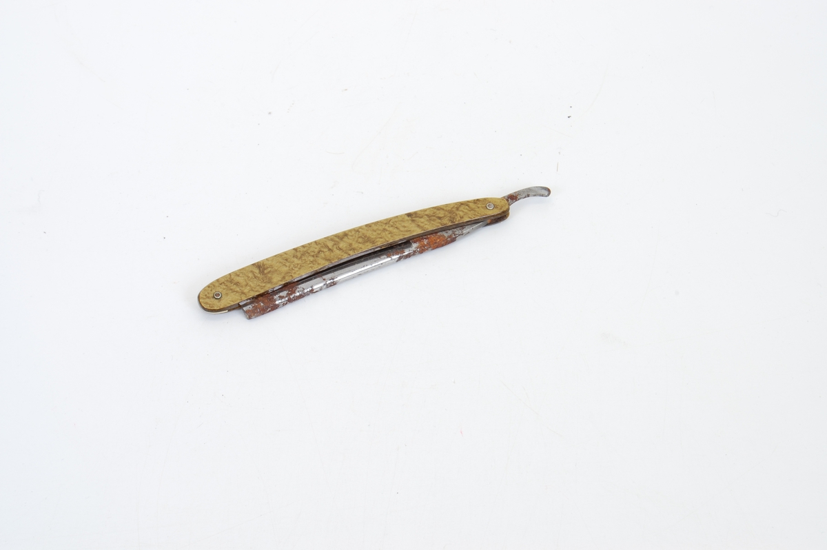 Form: avlangt etui med to barberkniver oppi, knivbladet kan foldes inn i skaftet 
