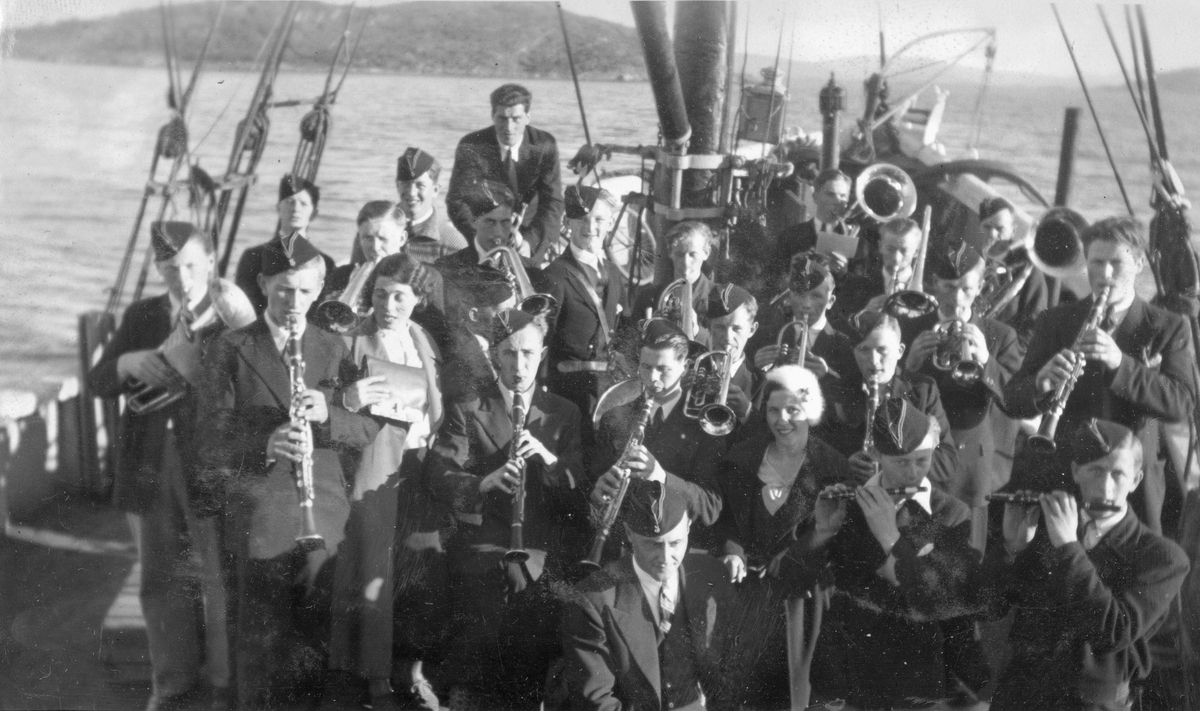 Harstad Ungdomsmusikkorps, fotografert på dekk ombord i et fartøy.