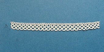 Blått kartongark med 4 prover på skånsk knyppling från östra Göinge härad. Vid varje prov står en stor bokstav.
A. 13 x 1 cm
B. 13 x 1 cm
C. 13 x 0,8 cm
D. 13 x 1,7 cm
