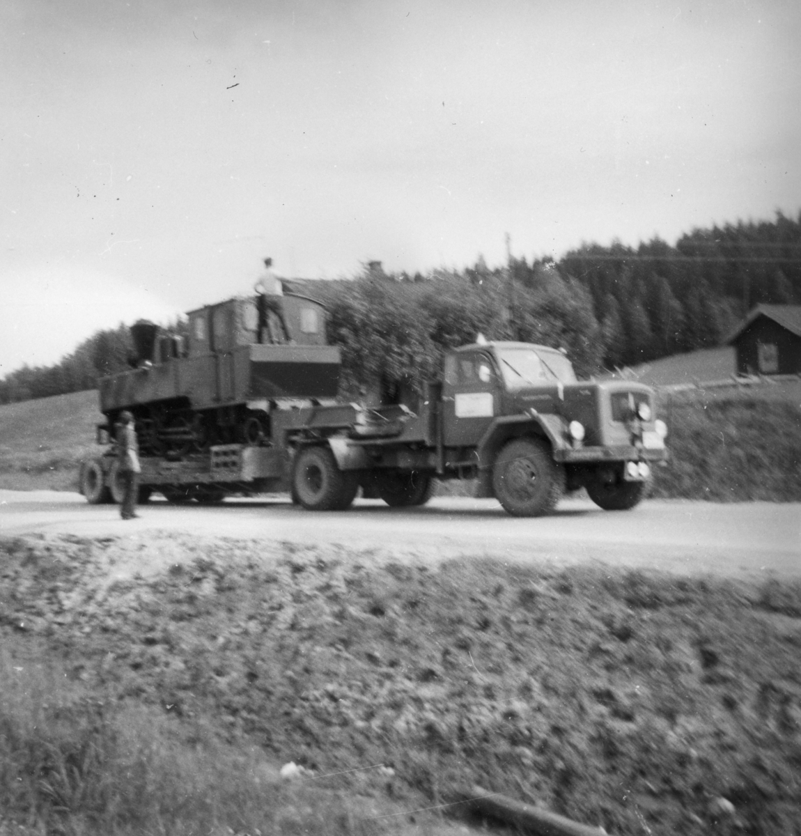 Damplok 6 Høland under transport fra Sørumsand verksteds område til museumsbanen. Transporten måtte gå via Løken i Høland pga. lav bru i Sørumsand. Her rulles lokomotivet av ved Sætra planovergang.