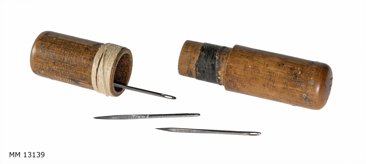 Nål för segelsömmare i stål. Nålen förvaras i cylindriskt fodral av trä med märkning: S. H. (Sten Hansson)