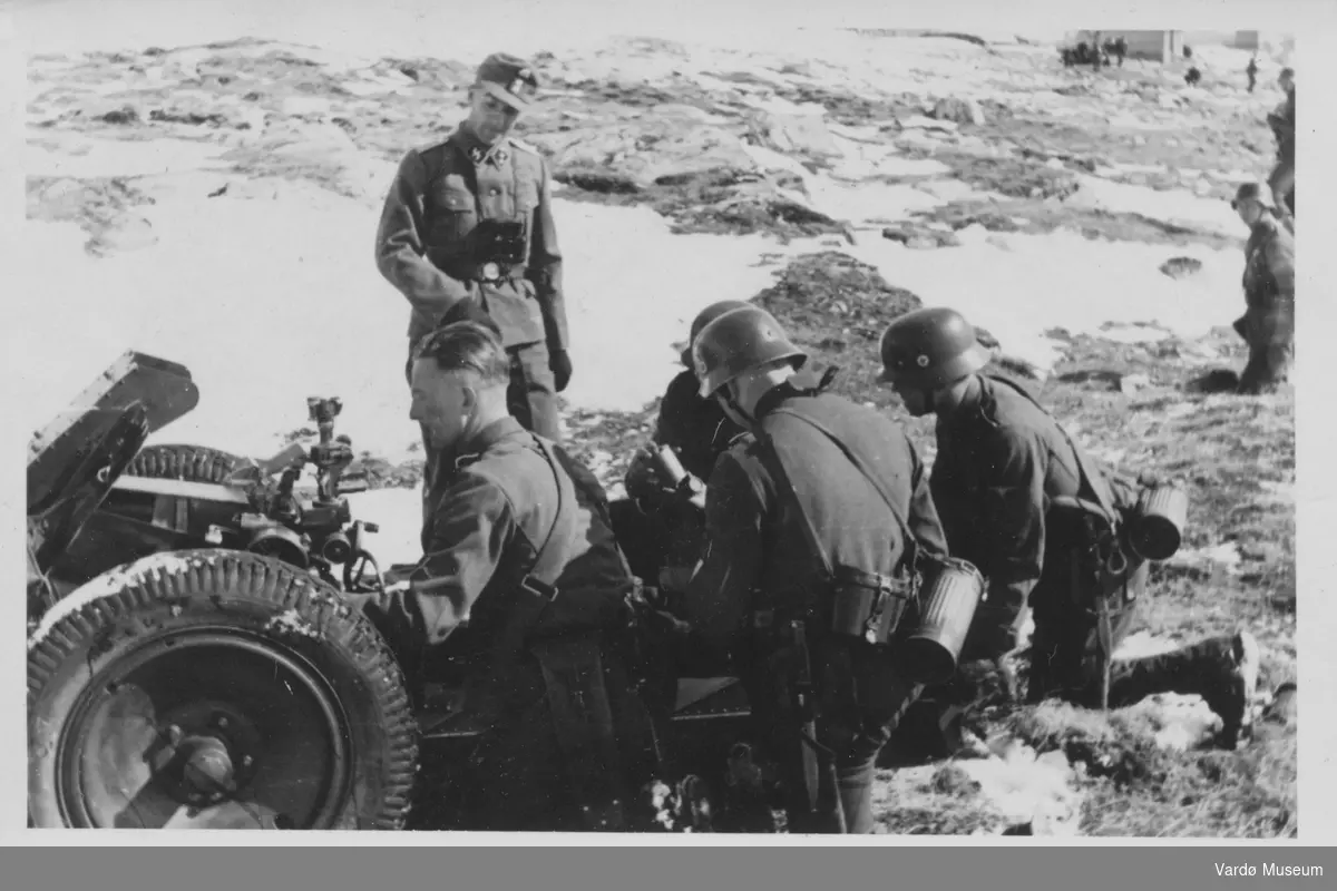 Tyske soldater i Vadsø området 1940-1944.
SS-Untersturmführer(fenrik) inspiserer det hele.
Soldater som forbereder skyting med kanon