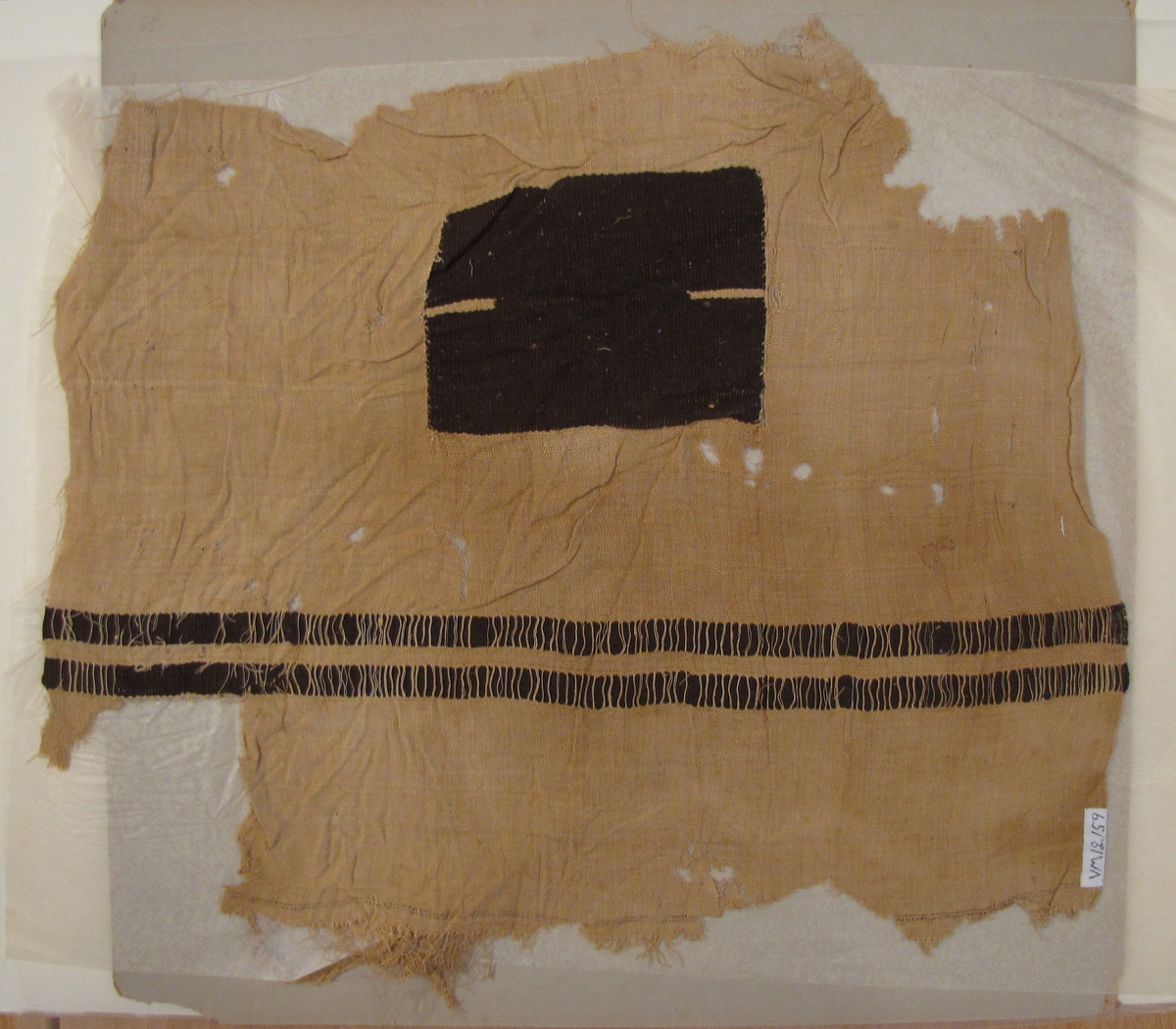 Fotkläde II
 
Nr 12 155 - 12 159 tillhör den egyptiska sarkofagern ''mumien''. 

2014-05-23 Enligt forskare Maciej Szymaszek är detta troligen ett fragment av en mantel från södra Egypten. Troligen tillhör detta fragment tillsammans med VM 1392, VM 1 393 och VM 12 159 samma mantel.

Ej tidigare inmärkta.