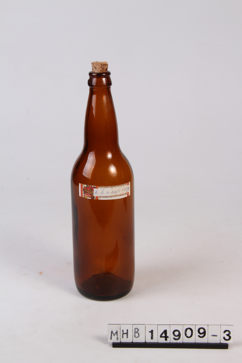 Glassflaske med etikett og trekork. Brukt til oppbevaring av solbærsaft.