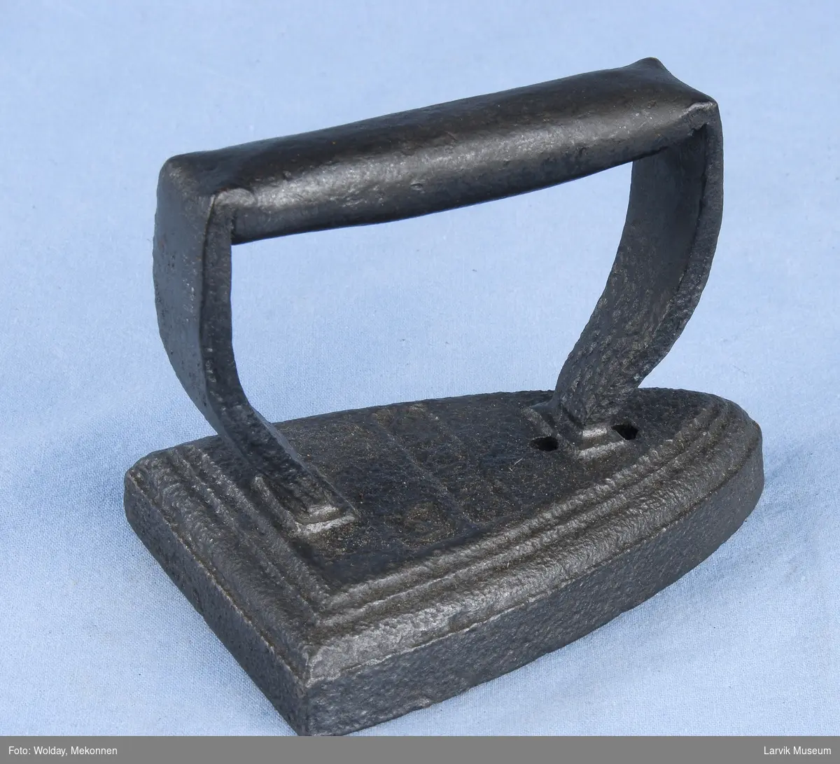 Form: håndtak og stativ i ett, smidd fast til jernet
