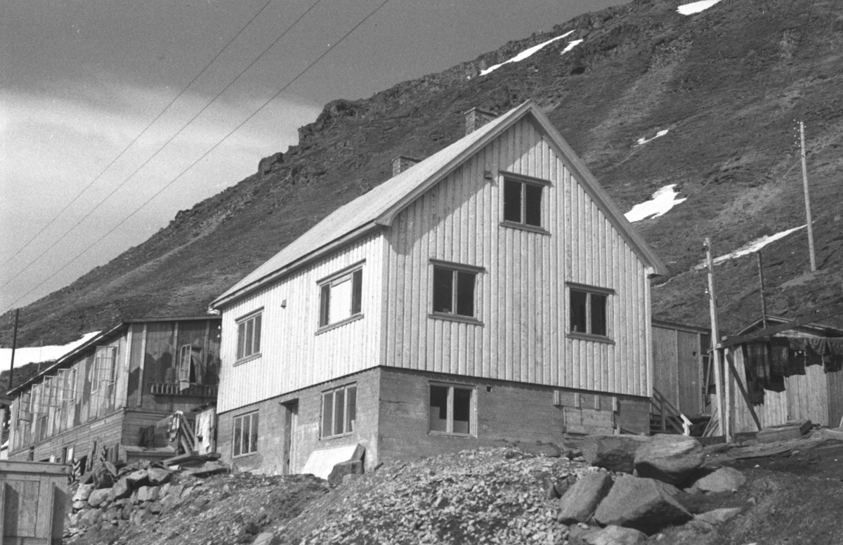 Dette var huset til Alfred og Antonie Lovise Pettersen i Honningsvåg. De dro til Gjerstad i Lofoten noe før evakueringen fordi Alfred mistet et øye da et skip eksploderte ved kai.

Arkitekt Ola Hanche-Olsen arbeidet ved Brente Steders Reguleringskontor i 1946. Hovedadministrasjon for gjenreisning av Nord-Troms og Finnmark ble lagt til Harstad og fikk navnet Finnmark kontoret. Landsdelen Nord-Troms og Finnmark blev oppdelt i syv distrikt med hver sin administrasjon. Honningsvåg, distrikt IV, skulle betjene Nordkapp, Lebesby, Porsanger og Karasjok kommune.

Ola Hanche-Olsen har tatt bildene. Han var født 13. mars 1920 i Borre, død 11. februar 1998 i Gjettum. Han var både arkitekt og barnebokforfatter. Han hadde artium fra 1939, arkitekteksamen fra NTH 1946 og arbeidet deretter ved Finnmarkskontoret 1946–48 før han etablerte egen arkitektpraksis. Han debuterte som barnebokforfatter i 1974 med lettlest-boka "Knut og sjørøverne", og skrev i alt 12 bøker. Han var XU-agent 1944-45, og var også en aktiv fjellklatrer og friluftsmann. Ola var gift med Solveig Hanche-Olsen (f. Falkenberg); de fikk 3 barn, blant dem matematikeren Harald Hanche-Olsen.


