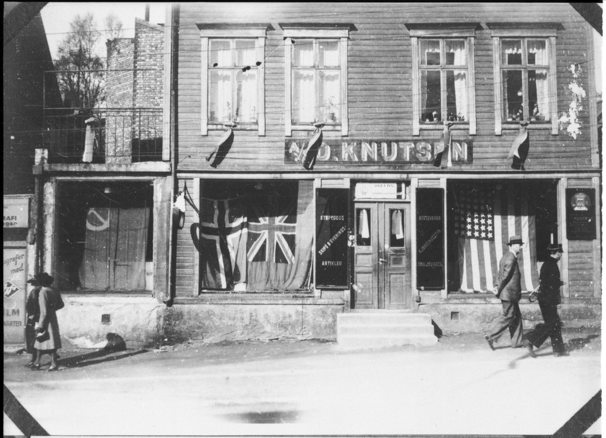 O. Knutsens jernvareforretning med sovjetisk, norsk, engelsk og amerikansk flagg i vinduet.