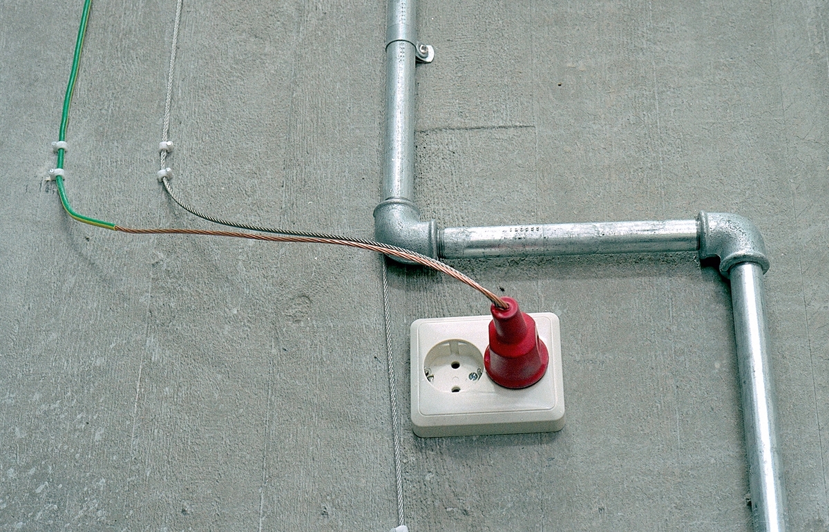 Elementene i installasjonen utgjør et tegnet mønster som assosierer både til et industrielt scenario og til labyrinten, uten at det umiddelbart lar seg entydig gripe. Flere steder er rør malt blå, gule og grønne, som reflekterer lyset som sprer seg øverst i rommet gjennom de tilsvarende fargede vindusglassene. Dette bidrar til å skape en estetisk og poetisk dialog mellom kunsten og bygget. På betongveggen finner man spredte hverdagsgjenstander slik som et speil, et forseggjort messingdørhåndtak, en stikkontakt, samt elementer fra naturen i form av et vakkert sammenfoldet skjell, bambus og trestykker. Fra fondveggen strekker installasjonen seg videre i ulike retninger bortover langs de tilstøtende veggene og avsluttes på forskjellig vis, som for eksempel i kunstnerens personlige pilspiss, godt bevart fra egen barndom. En av linjene bryter tvers gjennom bygningsveggen og fortsetter videre i utomhusterrenget i det utvendige inngangspartiet. Der løper den langs bakken, kryper oppover en stor granittstein som kunstneren har hentet fra den lokale elvebredden og videre langs bakken, for til sist å forsvinne ned i jorden.

En messingplate til venstre på fondveggen har det indianske ordtaket «Det er syv hovedretninger: Opp, Øst, Sør, Nord, Vest, Ned og Inn i Deg Selv» innrisset på samisk og norsk som gir oss et utgangspunkt for egne tolkninger. Linjene i installasjonen har noe med retningene å gjøre for de ulike gjenstandene er metaforer. I speilet møter du deg selv, og med håndtaket kan du åpne dører og grenser. Pilen peker mot skogene som symboliserer en del av menneskenes naturlige røtter, vår fruktbarhet er knyttet til jorden og steinen er det eviges symbol.