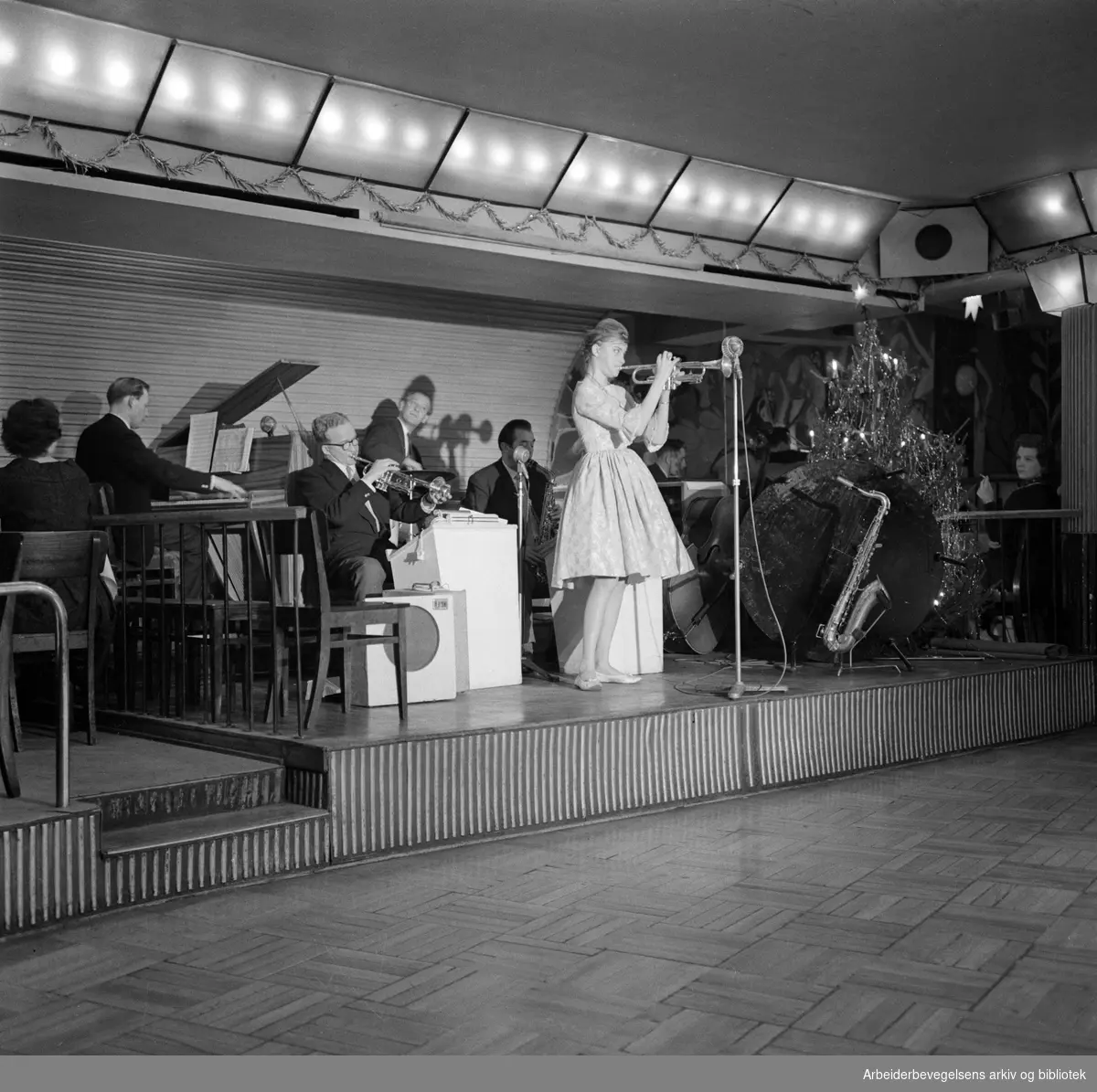 Alf Søgaards orkester, med akrobaten Belita på trompet, spiller på restaurant Rosekjelleren i Klingenberggata 5 i Oslo. Januar 1961.