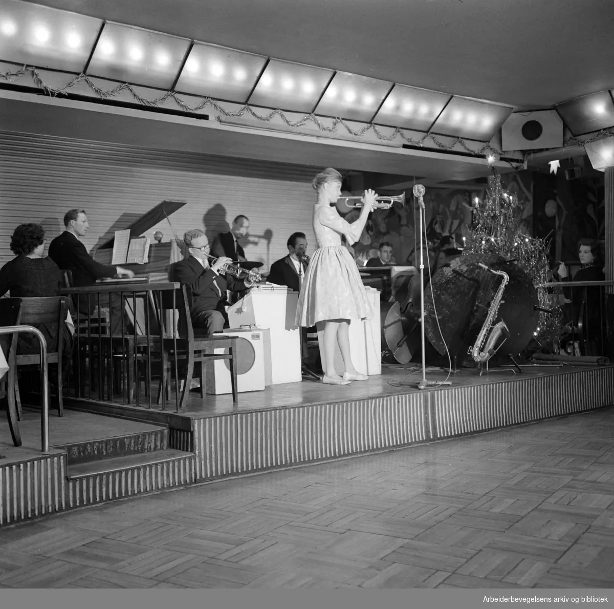 Alf Søgaards orkester, med akrobaten Belita på trompet, spiller på restaurant Rosekjelleren i Klingenberggata 5 i Oslo. Januar 1961.