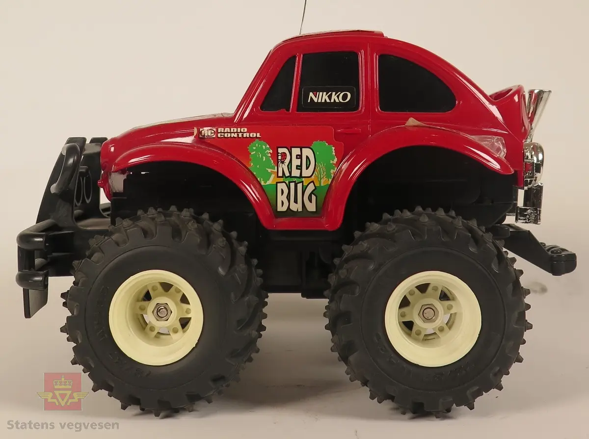 Rød modellbil med en anntenne og fjernkontroll, hovedsakelig laget av plast og metall. Skala 1/24