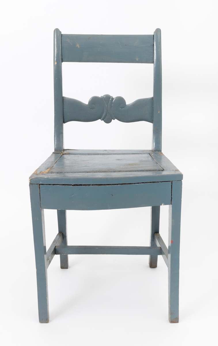 Stol av treverk med ryggstø (rygg, stolrygg) og fire bein. Stolen har fast sete uten stopping. Stolryggen, ryggstøet (ryggen), har en svak krumning. Treverket er bemalt med en gråblå farge. Stolen er sammenføyd med tapping, spikre og skruer. Setet består av fem deler. I midten er det en trapesformet treplate (største lengde: 24 cm, største bredde: 32 cm). Setet består videre av fire trestykker (lister), et stykke (en list) på hver side av plata. Disse trestykkene er festet til sargen og de fremre stolbena. Plata i midten har delvis løsnet fra festepunktene. På innsiden av sargen er det skrudd fast tre vinkelbeslag for å holde konstruksjonen sammen. (Beslaget er festet med skruer sargen og trestykkene (listene) rundt treplata.)

Det er er i alt tre mellomstykker mellom stolens ben. To mellomstykker, cirka 31 cm lange, er tappet inn i  stolbena på siden, avstiving i lengderetningen. Et mellomstykke er festet tvers over, for avstiving i sideveis. Denne tresprossen er tappet inn i, omtrent midt på, mellomstykkene som avstiver stolen i lengderetningen.  
Ryggen (ryggstøet) har en tverrstokk øverst og et mellomstykke. Mellomstykket har på midten en utskjæring (skal muligen forestille en stilisert sommerfugl). Stolen er preget av utstabile sammenføyninger.