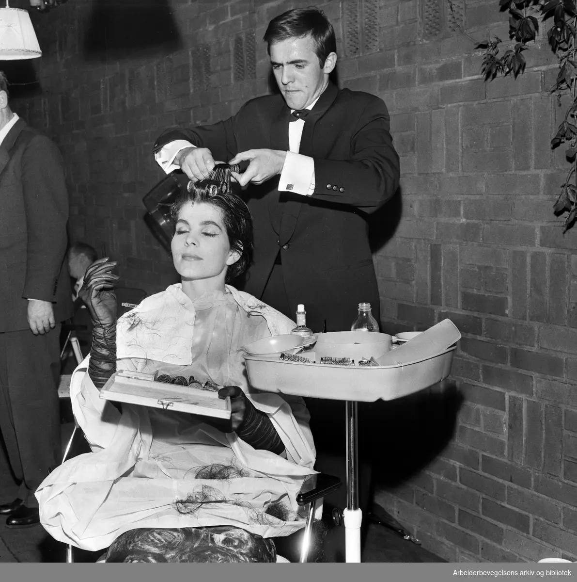 Den tyske frisøren Bernd Pawlowski lager en "Jackie-frisyre" på en modell under et arrangement i Ingeniørenes Hus. September 1961.