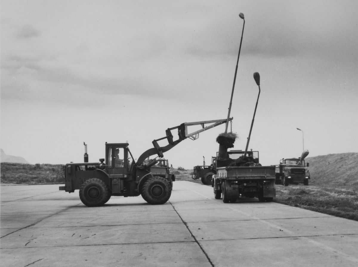 Lufthavn (flyplass) Fire kjøretøy (traktor og lastebil) arbeider med lysmaster