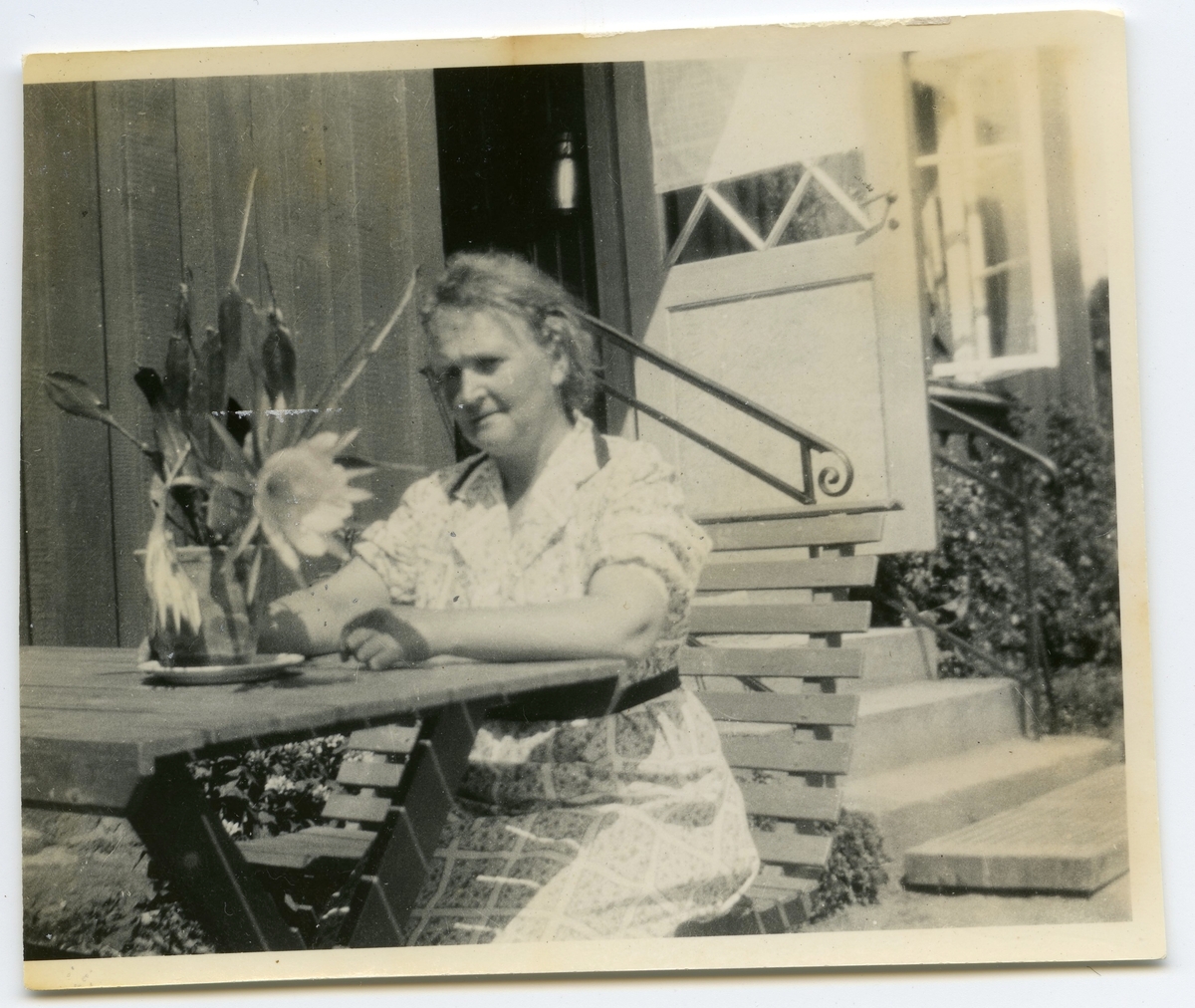 Nora Krantz (1879 - 1955) sitter utanför sin bostad, Stretereds personalbostad "Gula Trähuset" på Tulebovägen 23-27, 1930-tal. Hon var gift med skomakare/lärare Carl Krantz, båda anställda på Stretereds skolhem.