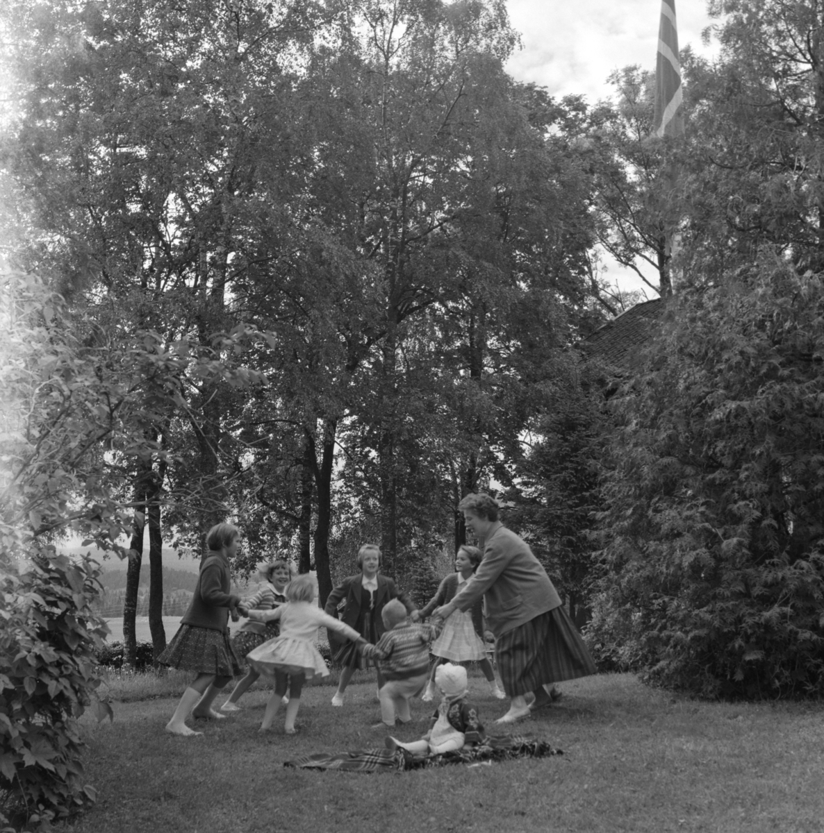 Barn og voksne leker i hagen på Sørum i Gjerdrum