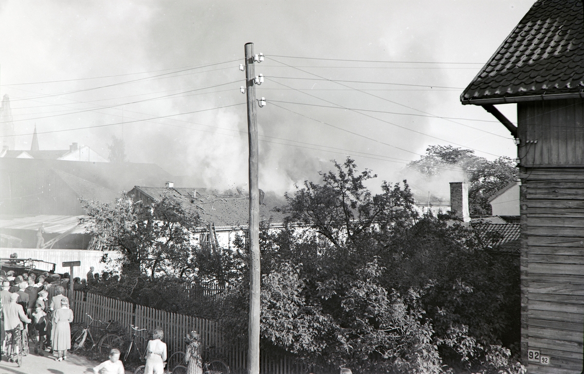 Brann i Lierbakken, Torggata 65, søndag den 25. Juli 1943. Lokalene huset Folkebiblioteket i Hamar, Politiet, Kemner kontoret og Det komunale Reviskons kontoret. Mye folk, slukkningsarbeid.  Bildet er tatt fra Grønnegata 93.