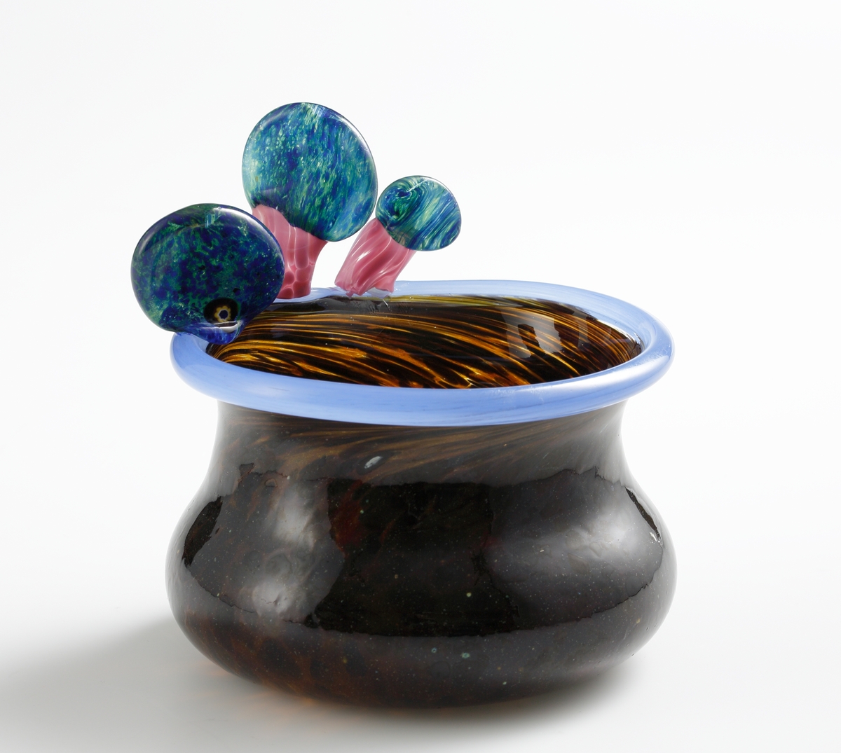Skål i brunfläckigt glas med blå mynningskant och skulpterade "svampar" i rosa och grönblått.