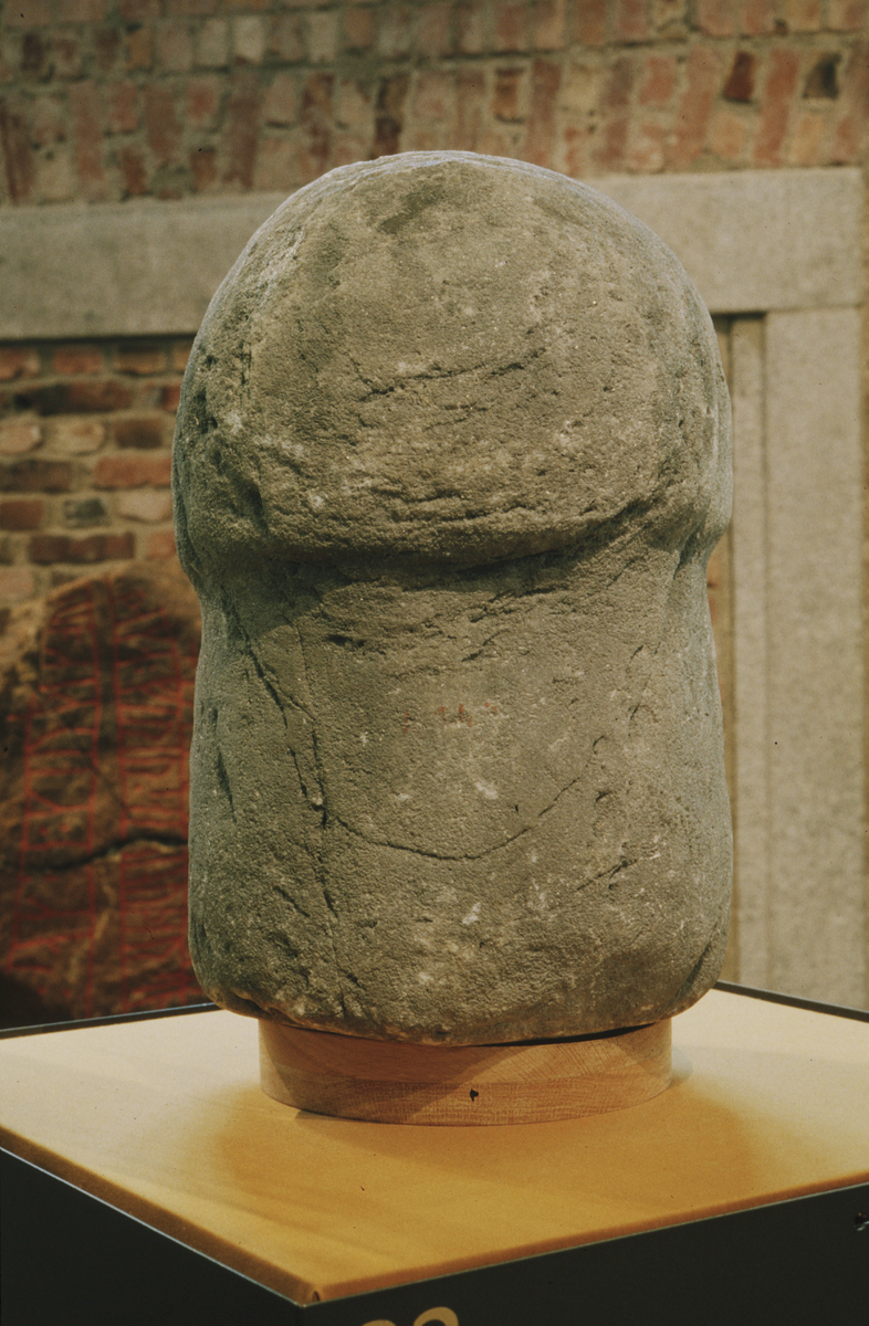 "Hellig hvit sten" av kvartsit, 42 cm. h., hvorav foten 21 cm. Hodets tverrmål er 26 cm. Stenen har form av en cylindrisk søile med halvkuleformet hode oventil. - 