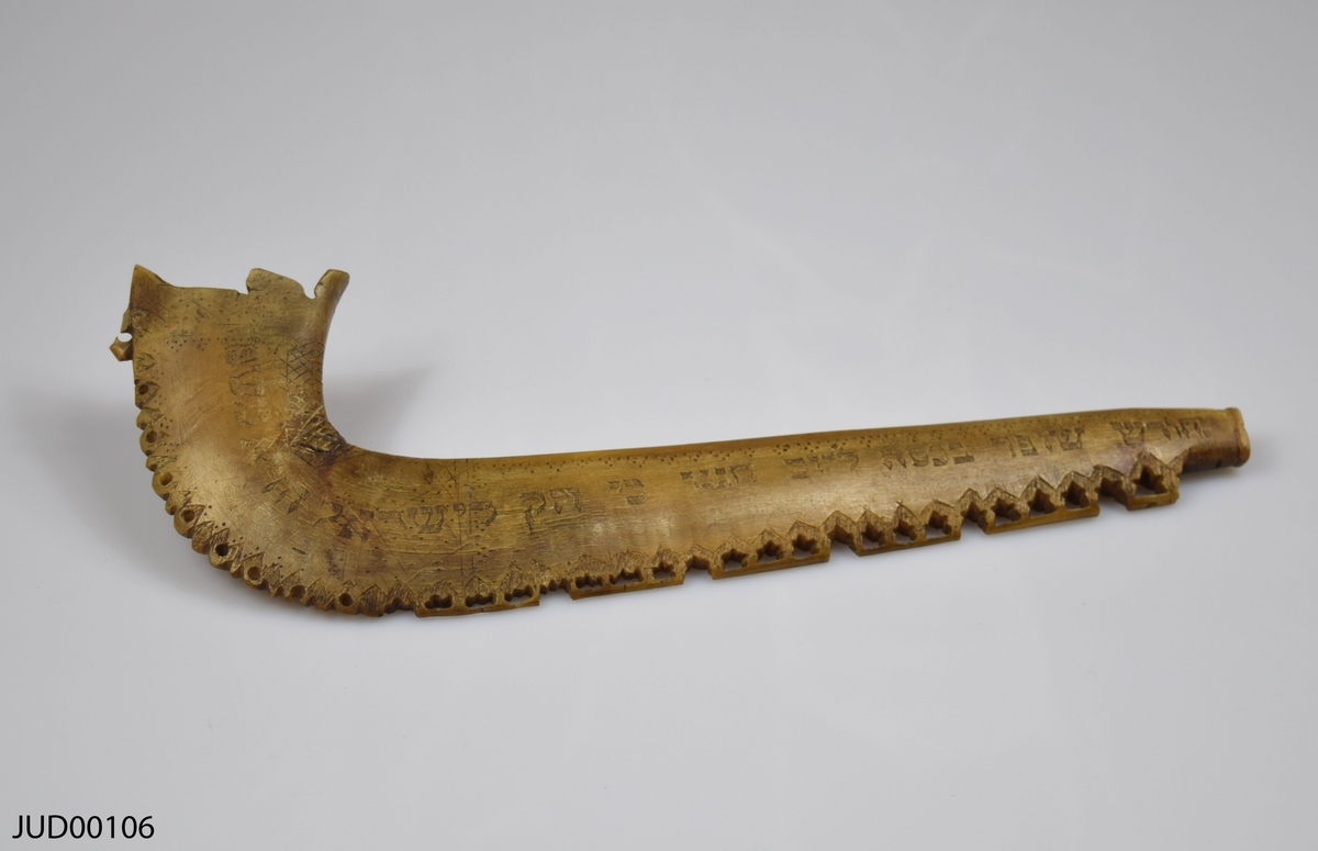 Shofar tillverkad av horn, dekorerad med ingraverad hebreisk text samt enklare geometriska former.