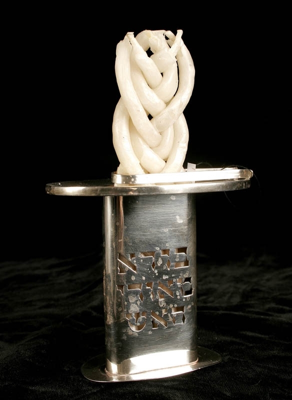 Silverljushållare för havdalaljus. Genombruten dekor i form av hebreisk text. Stämpel i botten med texten ”Made in Israel”.