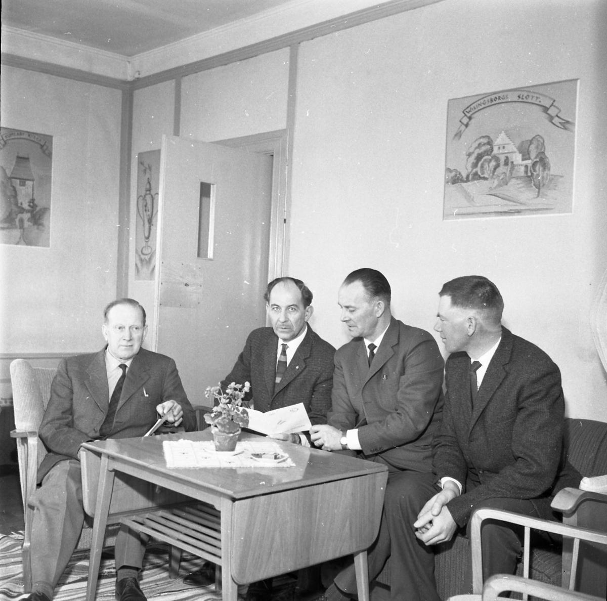 Fyra män sitter i en soffgrupp. De har något prospekt framför sig. De befinner sig möjligen på Hotell Brahe. Från vänster: Albert Svensson, okänd, Erling Krantz samt Sven Ekström.