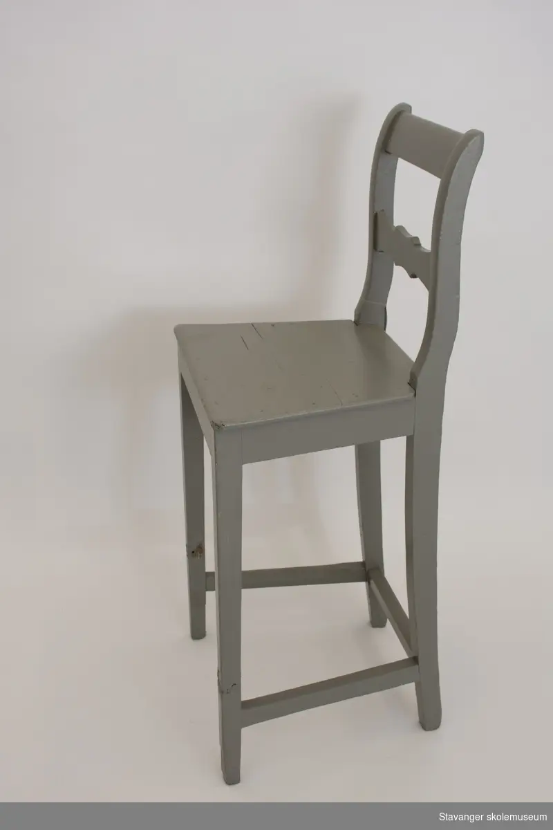 Høy grønmalt stol av furu med rette bein og sprosser og horisontalt ryggbrett.