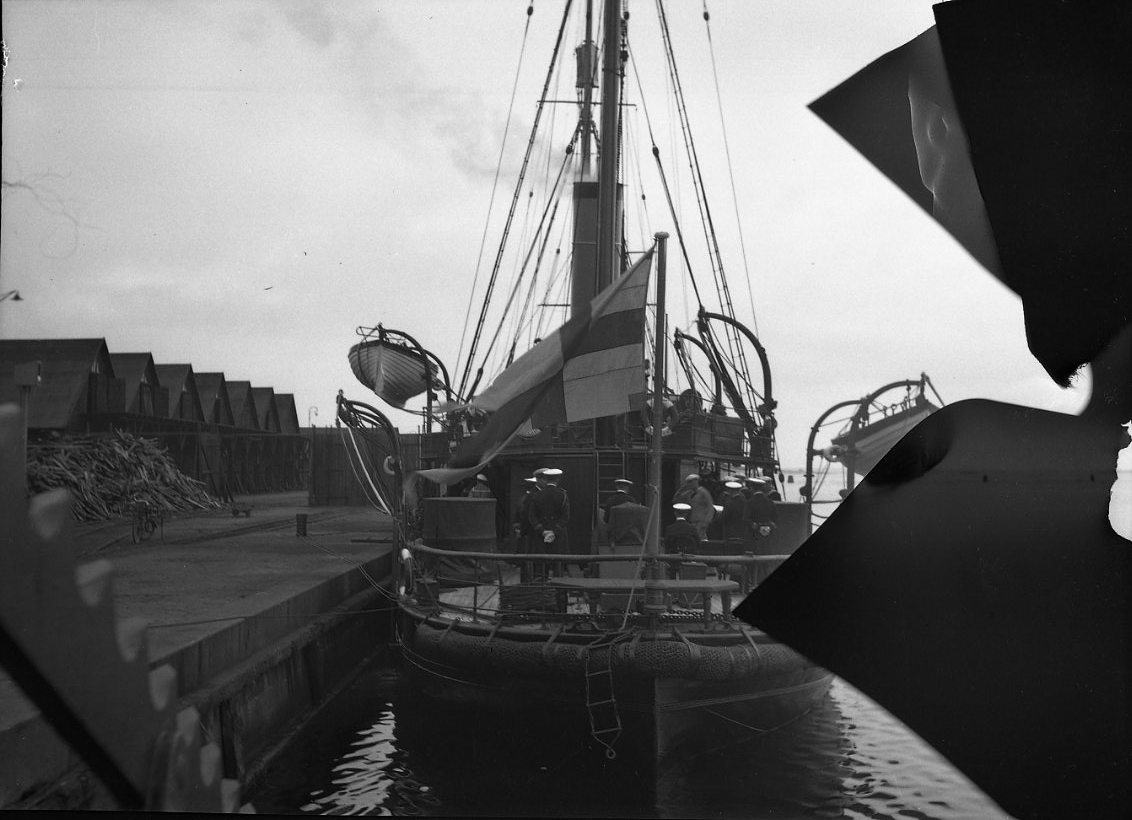 Kanonbåten HMS Svensksund med örlogsflagga i aktern ligger vid kaj.